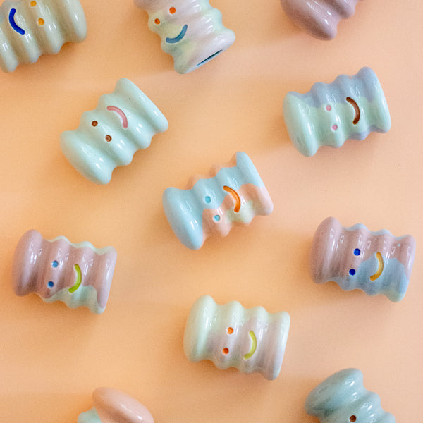 Decorative ceramic figurines with colorful designs on a peach background