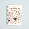 A spiral-bound notebook titled 'SEAL COLLECTION NOTE' with an illustration of many cute cat on the cover, photographed against a pale blue background. The brand name 'Shinzi Katoh' appears at the bottom.