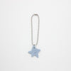 Star-shaped charm on a chain against a white background