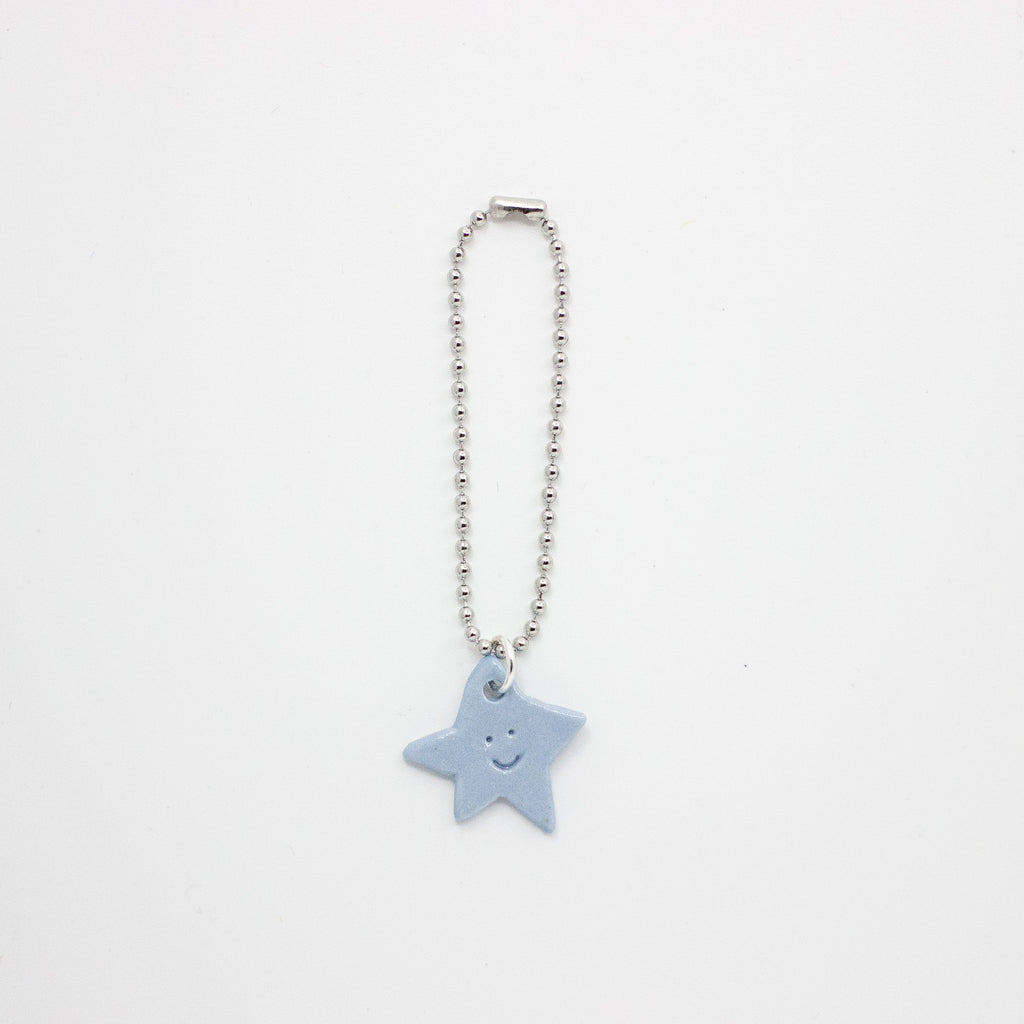 Star-shaped charm on a chain against a white background