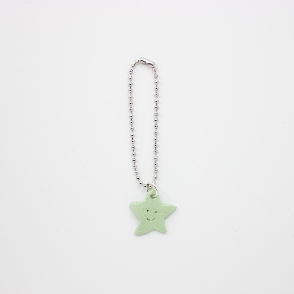Star-shaped charm with a smiley face on a white background
