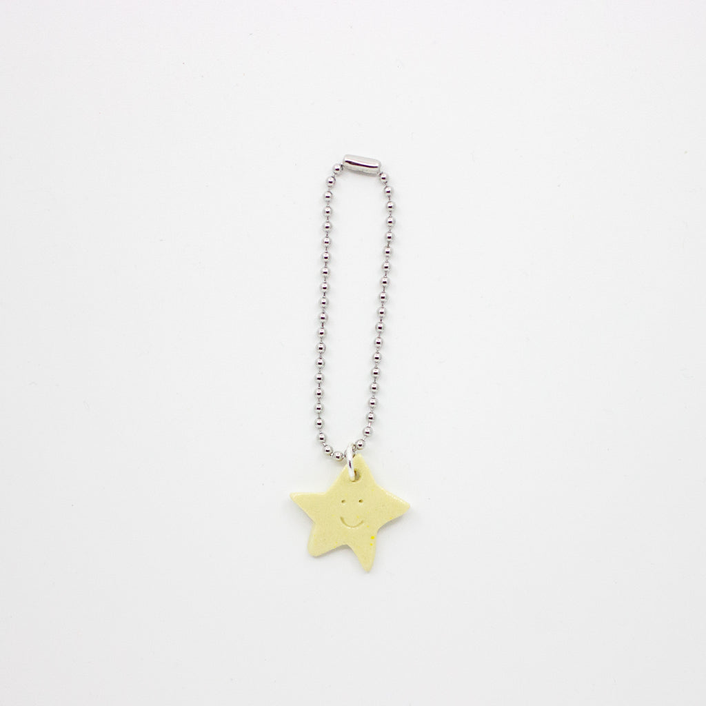 Star-shaped charm on a chain against a white background