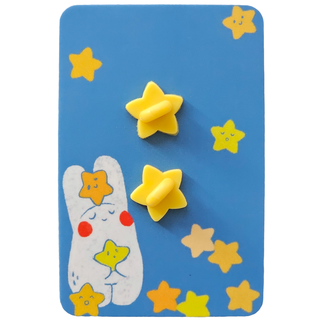 The back of an enamel pin packaging with two yellow star rubber stopper, mounted on a blue backing card decorated with colourful stars.