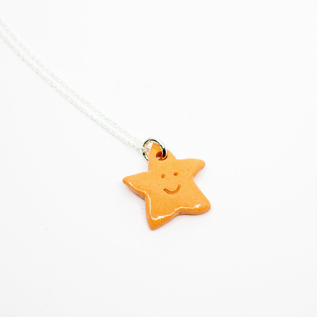 Orange star-shaped pendant on a white background