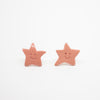 Pair of Rose Pink star-shaped earrings with smiling faces on a white background