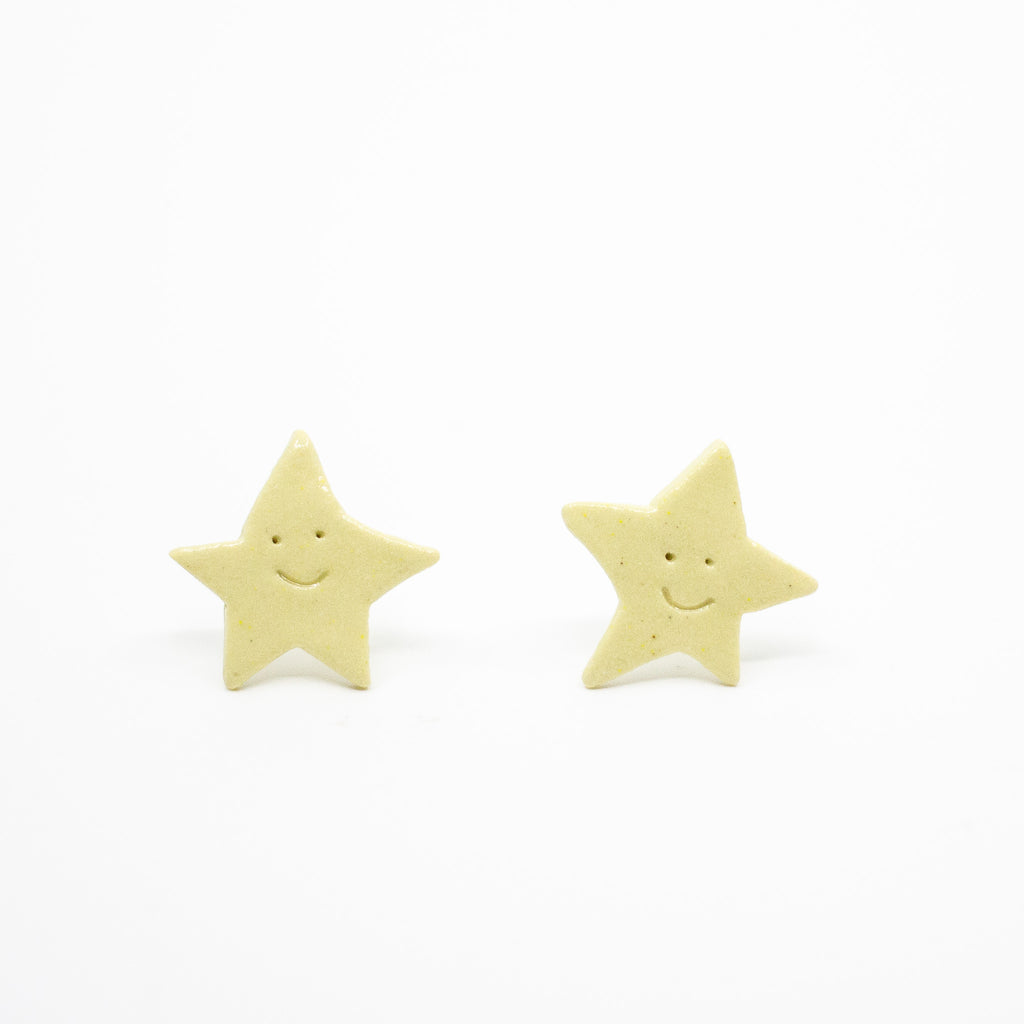 Two yellow star-shaped earrings on a white background