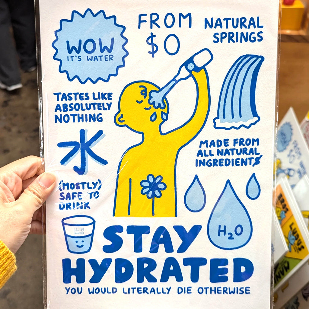A hand holds a novelty water bottle label or sign featuring a cartoon illustration and text that says 'WOW IT'S WATER', 'FROM $0 NATURAL SPRINGS', 'STAY HYDRATED', and 'YOU WOULD LITERALLY DIE OTHERWISE' in blue on a white background.