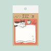 A package of cute sticky notes featuring a black-and-white cat peeking over an open book, with a coffee cup, glasses, and paw prints. The package has a tan backing card with Japanese text and a white header, set against a solid pale mint green background.