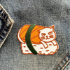 Embroidered patch of a cat inside a sushi roll on denim fabric.