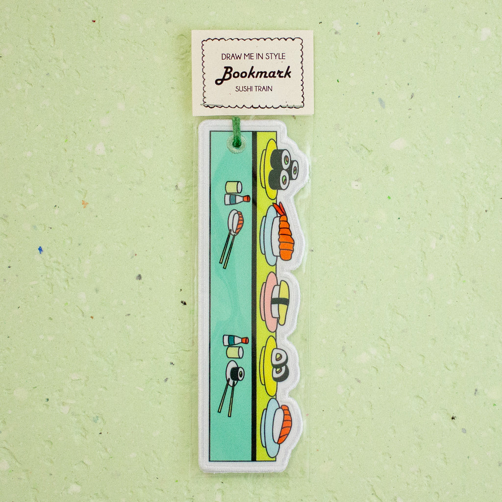 A hanging bookmark shaped like a sushi train, with cartoon sushi illustrations and a small paper header card that reads 'Bookmark' and 'Sushi Train,' shown against a pale green textured background.