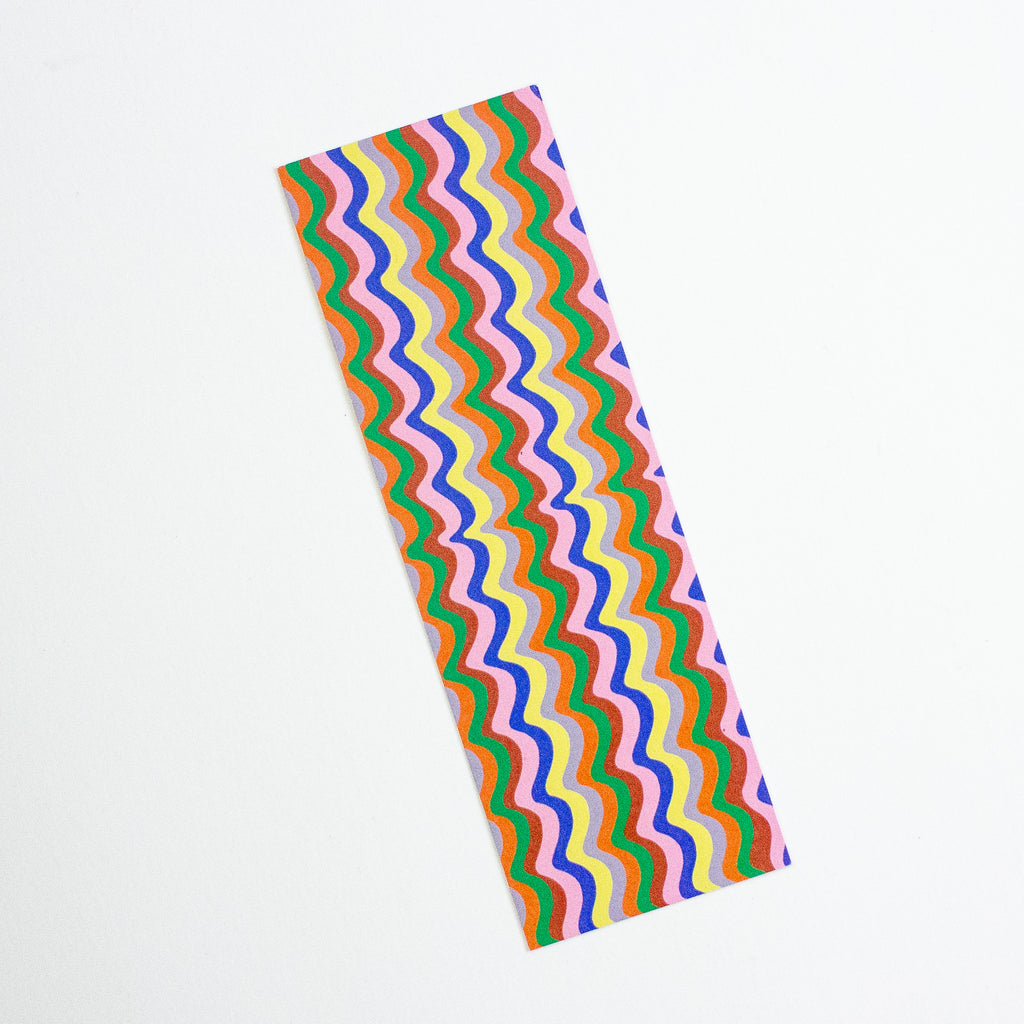 A colourful wavy stripe pattern bookmark with pink, orange, brown, yellow, grey, green, and blue,  shown against a plain white background.