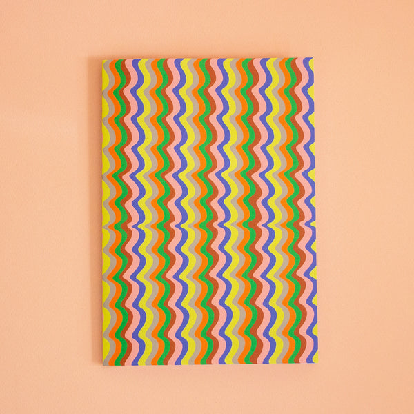 Colorful wavy patterned paper on a peach background