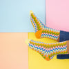 Colorful zigzag-patterned socks on a multicolored background
