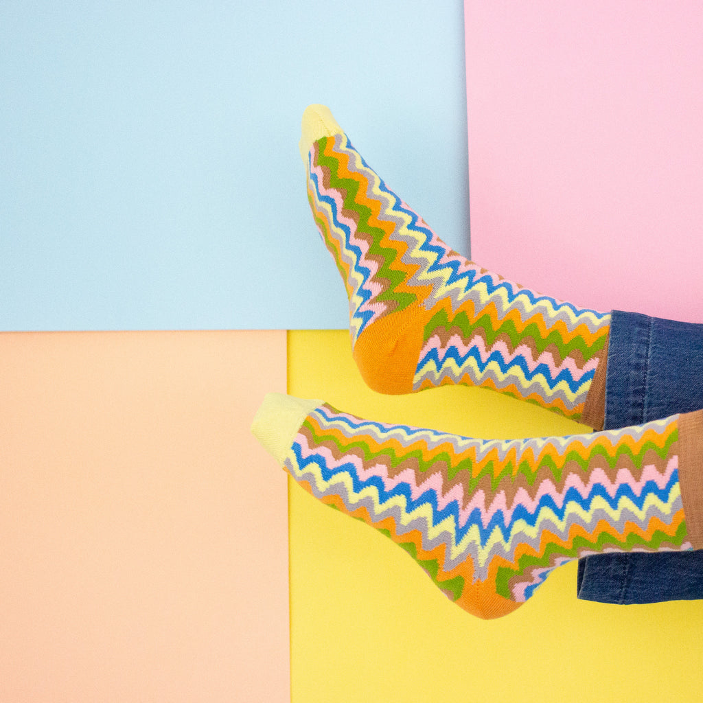 Colorful zigzag-patterned socks on a multicolored background
