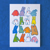 A white art print featuring a grid of colourful cartoon creatures with blue outlines, displayed against a textured blue background.