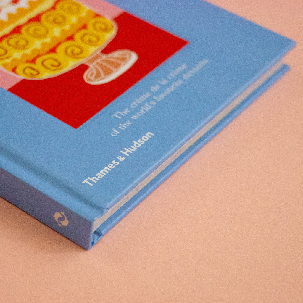 A blue book featuring a picture of a cake on a peach background