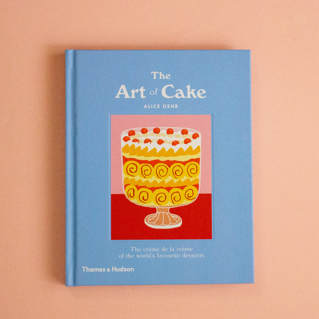 A book titled 'The Art of Cake" on a peach background
