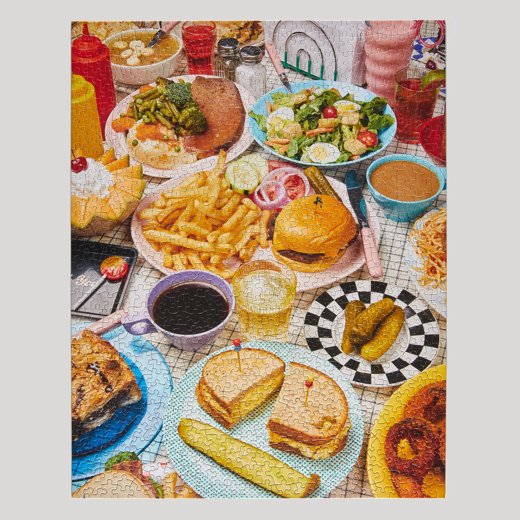 A finished puzzle featuring colourful table setting with various food items including burgers, fries, and drinks.