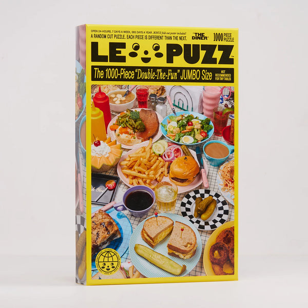 A 1000-piece jigsaw puzzle box titled 'The Diner' by Le Puzz, featuring a colourful cover illustration of a diner table filled with burgers, fries, hot dogs, and salads, set against a plain light grey background.