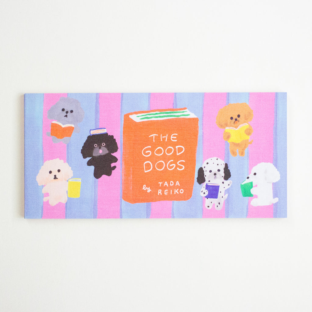 A rectangular notepad featuring a colourful illustration of several dogs reading books on pink and blue vertical stripes, with a central orange book reading 'THE GOOD DOGS' and 'by TADA REIKO'.