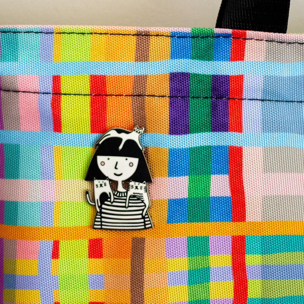 Colorful plaid fabric with a black and white character pin on it