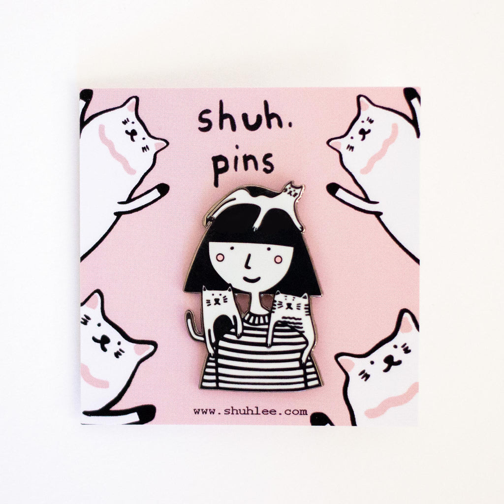 Pin with a design of a girl and cats on a pink background with 'shuh. pins' text.