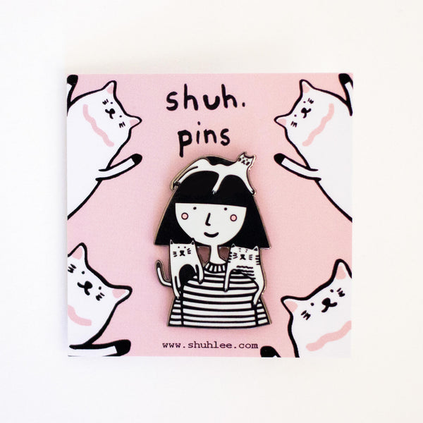 Pin with a design of a girl and cats on a pink background with 'shuh. pins' text.