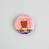 A round pinback button featuring a cartoon teddy bear sitting on a bed with the text 'TIME FOR BEDDY BYES' and a pink polka-dot background, shown on a plain light blue surface.