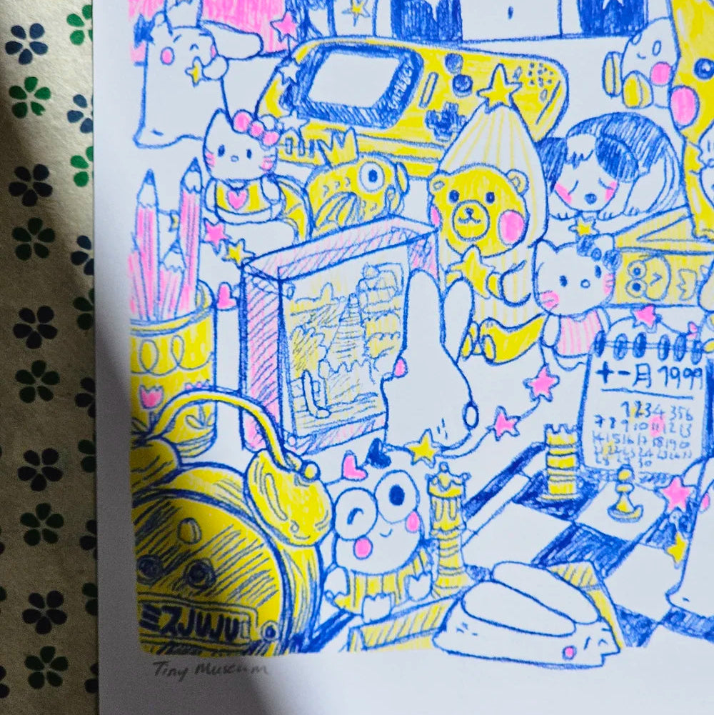 A hand-drawn colourful art print featuring cute cartoon characters, a retro gadgets, and handwritten Japanese text, photographed on a patterned fabric surface.