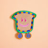 Colorful patch with a smiley face design on a peach background