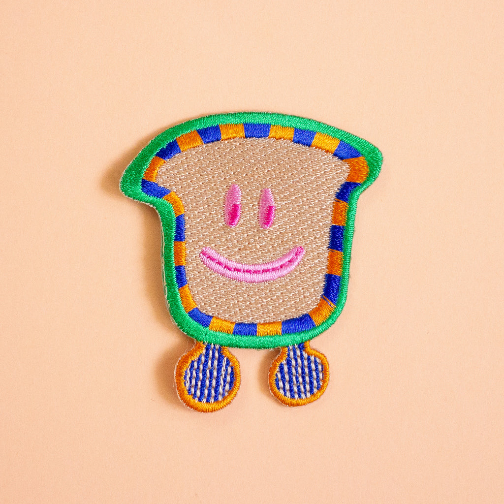 Colorful patch with a smiley face design on a peach background