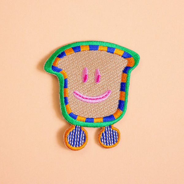 Colorful patch with a smiley face design on a peach background