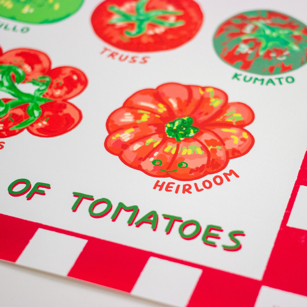 A close-up of a printed sheet featuring colourful tomato illustrations and the text 'OF TOMATOES,' with labels including Truss, Kumato, and Heirloom. The design uses red, green, and white with a playful hand-painted look.