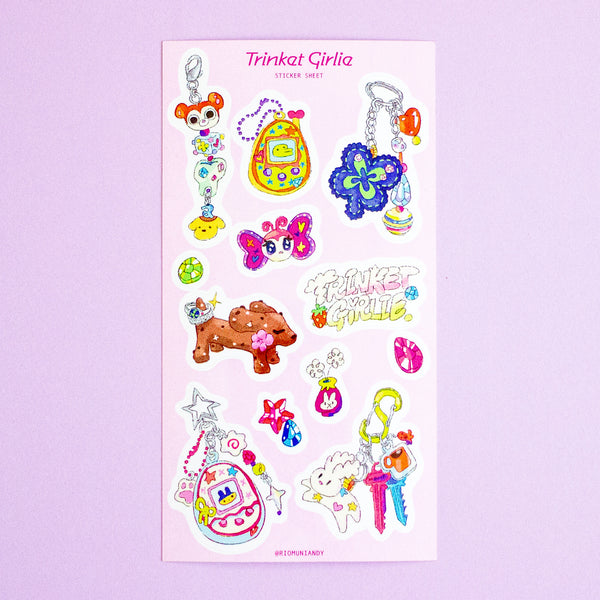 A sticker sheet  titled Trinkat Girlie featuring various colourful anime and pop culture keychain designs, displayed on a light purple background.