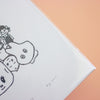 A close-up of a white art print cover featuring minimalist black line drawings of cartoon characters, with a peach-coloured background visible at the top right.