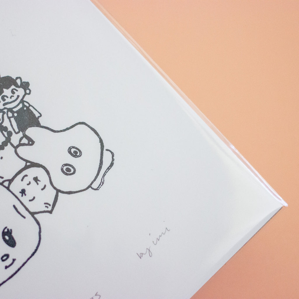 A close-up of a white art print cover featuring minimalist black line drawings of cartoon characters, with a peach-coloured background visible at the top right.
