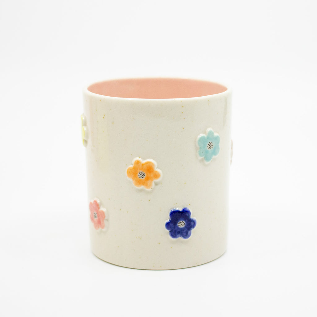 Ceramic mug with colorful flower features on a white background