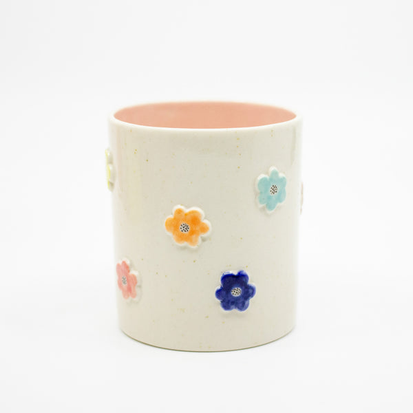 Ceramic mug with colorful flower features on a white background