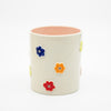 Ceramic mug with colorful floral designs on a white background