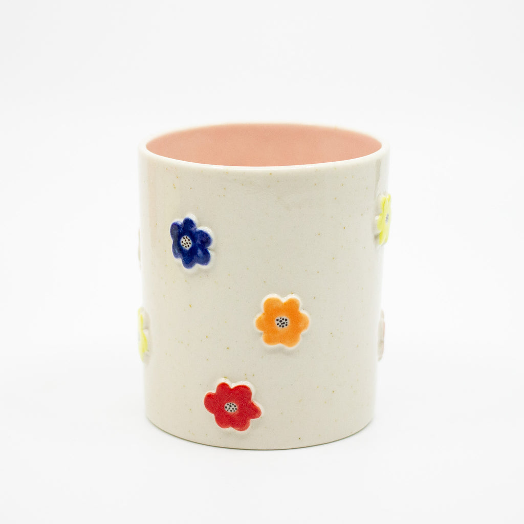 Ceramic mug with colorful floral designs on a white background