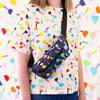 Model carrying the tulip bumbag over their shoulder. The Tulip print is a playful and colourful series of multicoloured tulip motifs on a black background.&nbsp;