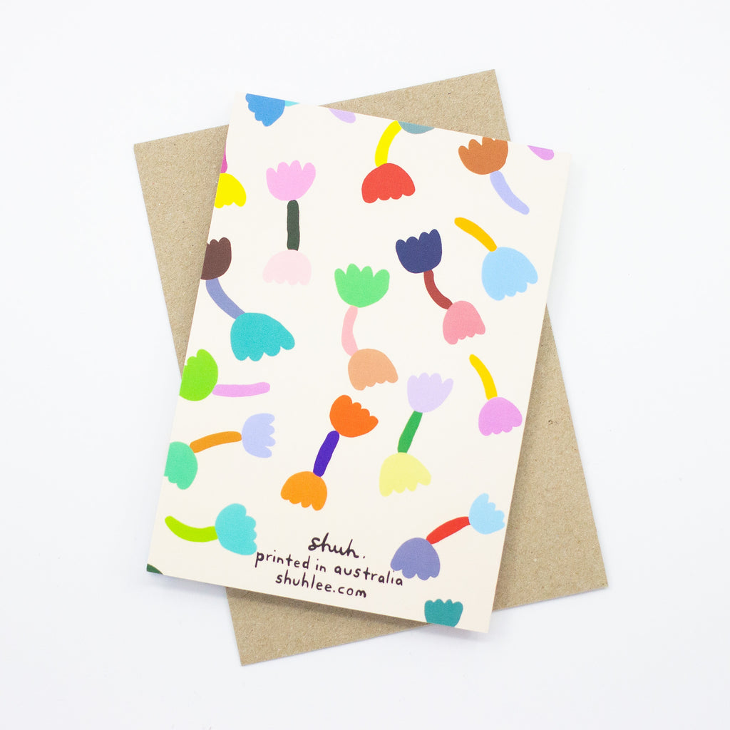 A back view of the Tulip print card, with recycled paper envelope. Bright tulip motifs on a cream background. 