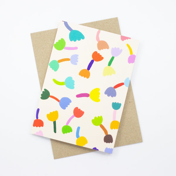 A front view of the Tulip print card, with recycled paper envelope. Bright tulip motifs on a cream background. 