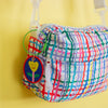 Colourful plaid pouch with a keychain on a yellow background