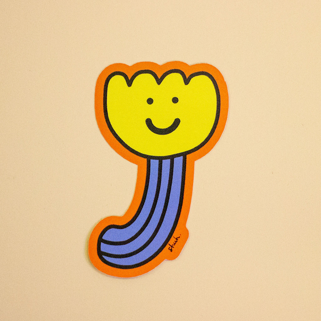 A die-cut sticker featuring a whimsical, cartoon-style flower with a yellow bloom, purple striped stem, and orange border, displayed on a solid beige background.
