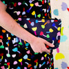 A person carrying the tulip useful bag. Repeating colourful tulips on a black background. 
