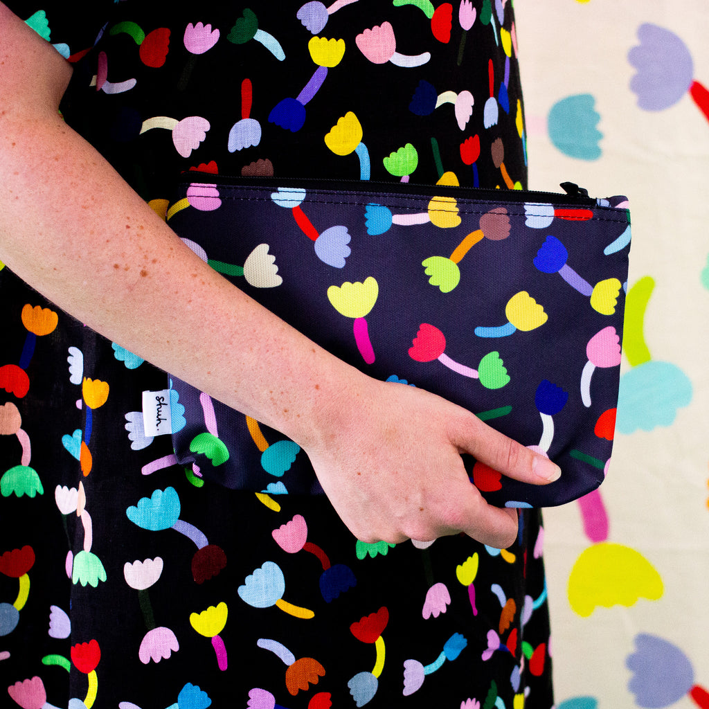 A person carrying the tulip useful bag. Repeating colourful tulips on a black background. 