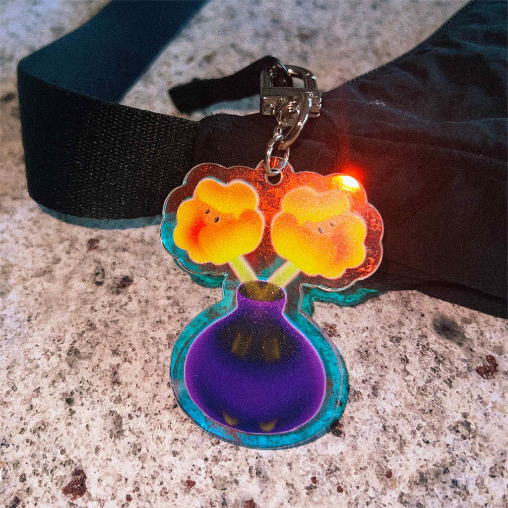 The Twin Flowers keychain features playful floral artwork printed on both sides of premium acrylic, finished with a mesmerising holographic effect that shifts through rainbow colours in the light.