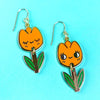 Pair of tulip-shaped earrings on a turquoise background