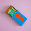 Colorful keychain with a small notebook in a blue box on a lilac background